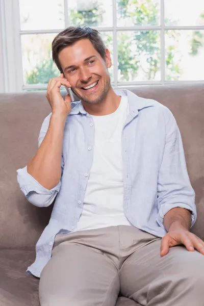 Casual man using mobile phone on sofa