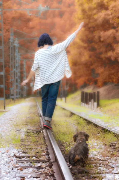 Woman and her pet walk the train tracks