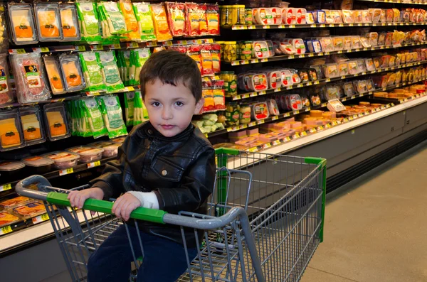 Little boy sitting in a grocery cart