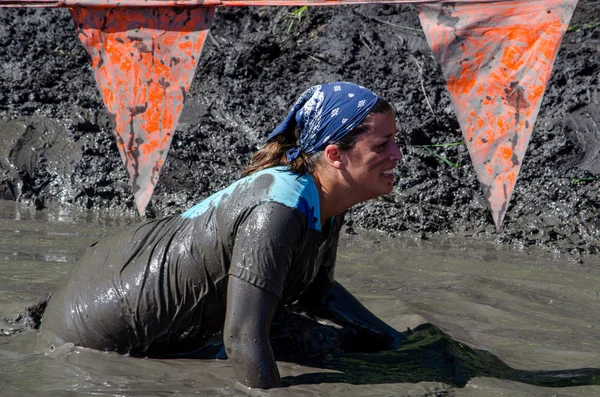 Woman crawls through mud to the finish line