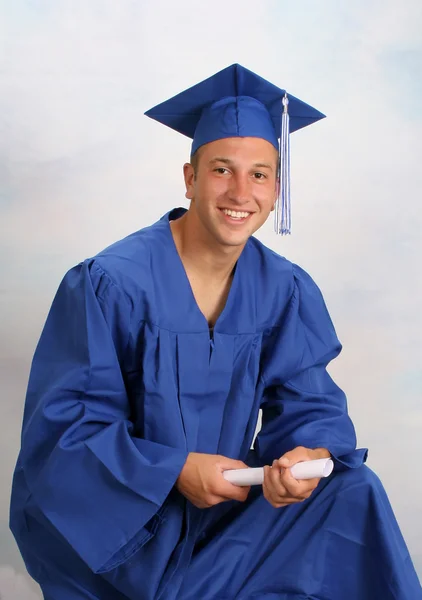 Young man in cap and gown with diploma