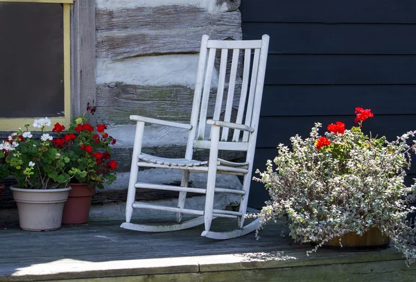 White rocker on front porch of a log cabin