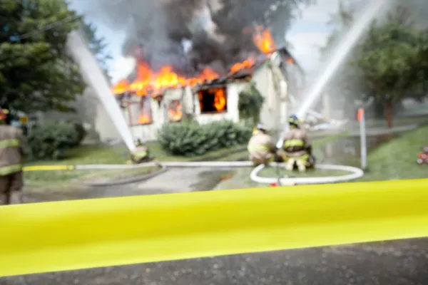 Empty tape with firefighters and a burning house