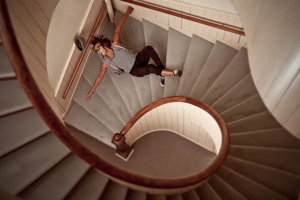 Young man falling down the steep stairs