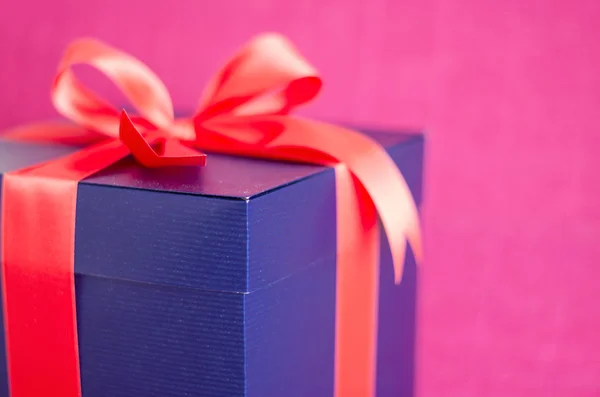 Blue present box with red ribbon isolated