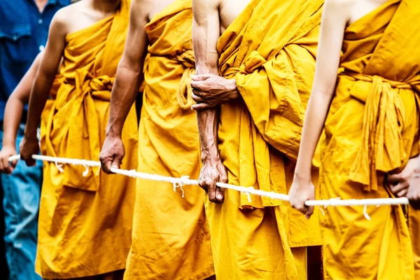 Monks stand in line to get offerings