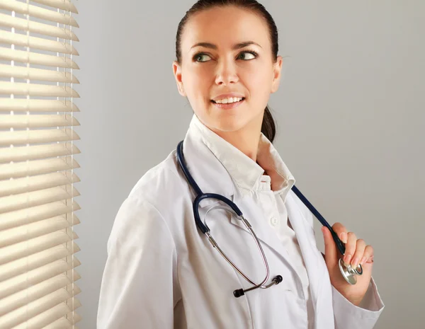 Woman doctor is standing near window
