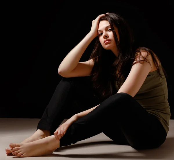 Depressed woman sitting on floor