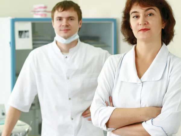 A medical doctors standing with folded arms.