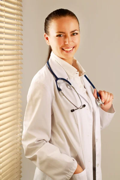 Woman doctor is standing near window