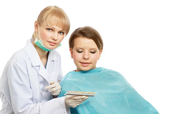 A female dentist treating patient\'s teeth