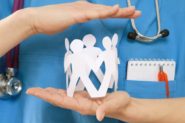 A female doctor holding paper people