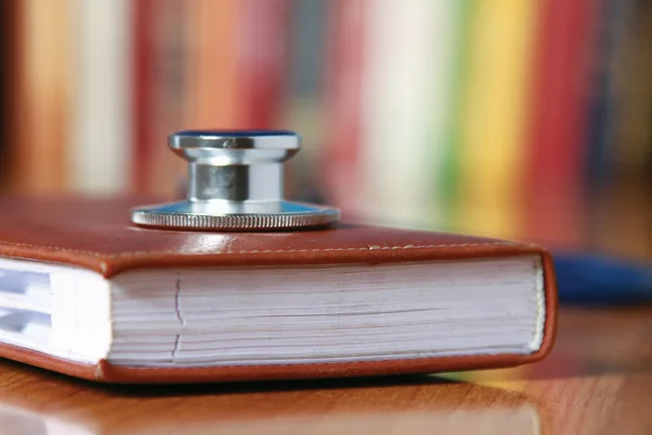 Stethoscope on book with leather cover.