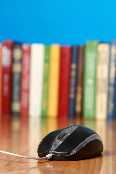 A computer mouse against books