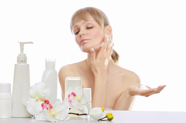 Beautiful woman applying cream on her skin