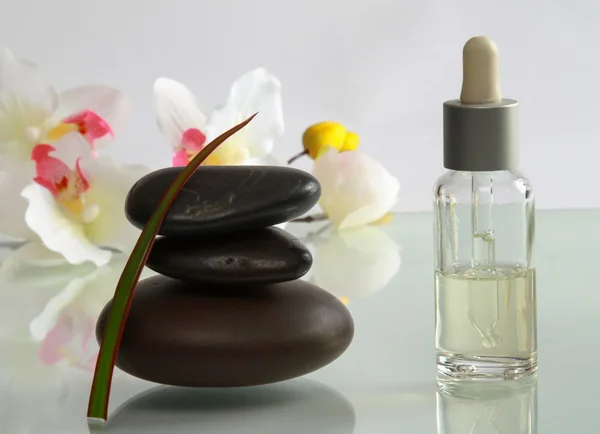 Essential oil and stones with flower.