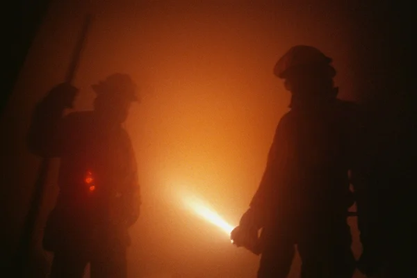 Firemen In Smoky Room With Flashlight