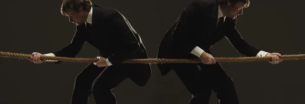 Two Men Pulling In Opposite Directions On A Rope