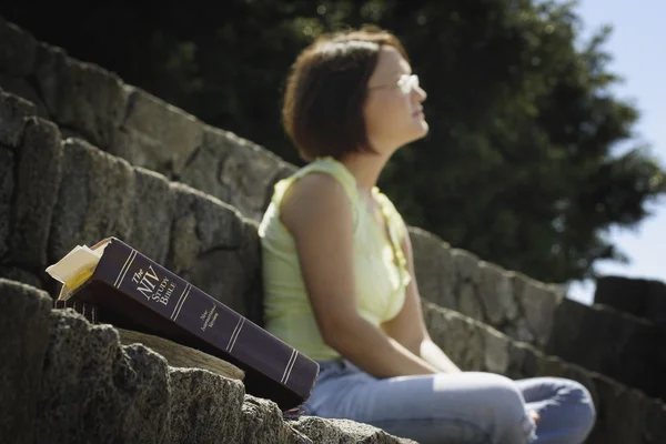 Bible In Foreground With Woman In Background