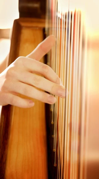 Fingers Plucking On Strings Of A Harp