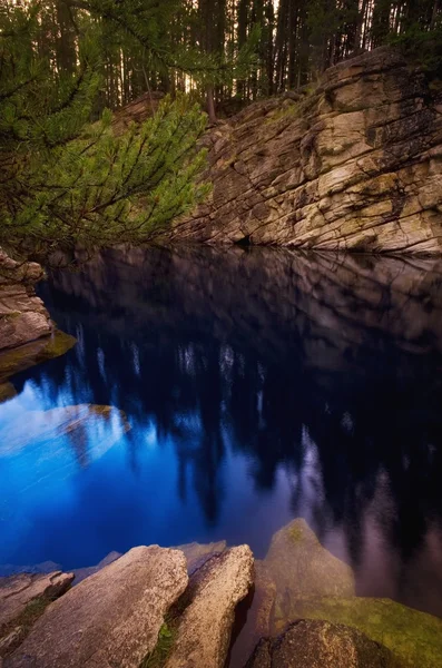 Rocks And Trees Reflected In Water