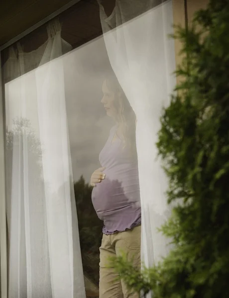 Pregnant Woman Waiting By The Window