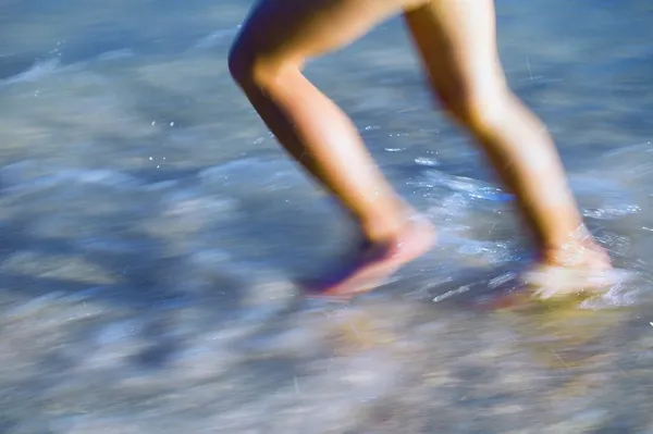 Child Running Through Surf