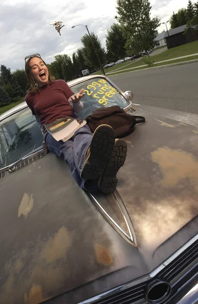 Front View Of A Girl Sitting On Car Bonnet