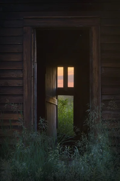 Door To Abandoned Home With Warm Inviting Window Light