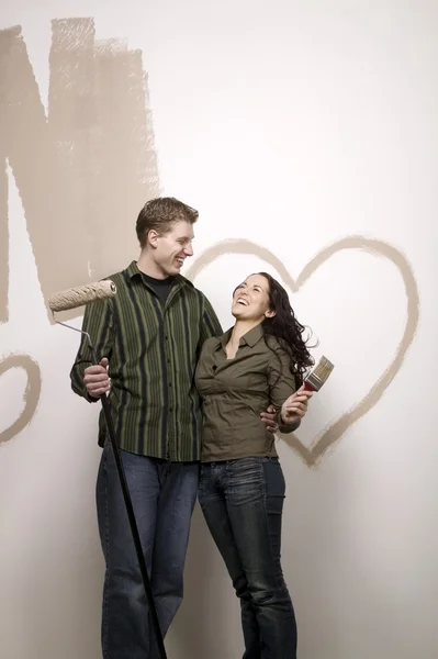 Couple With Painted Heart On The Wall