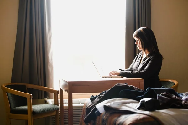 Woman Working On Computer In Hotel Room