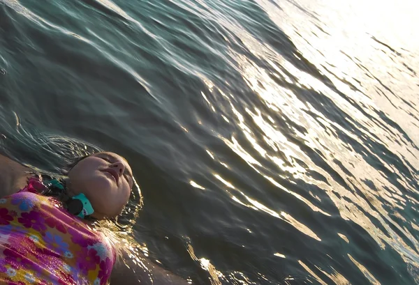 A Girl Floating On Her Back In The Water