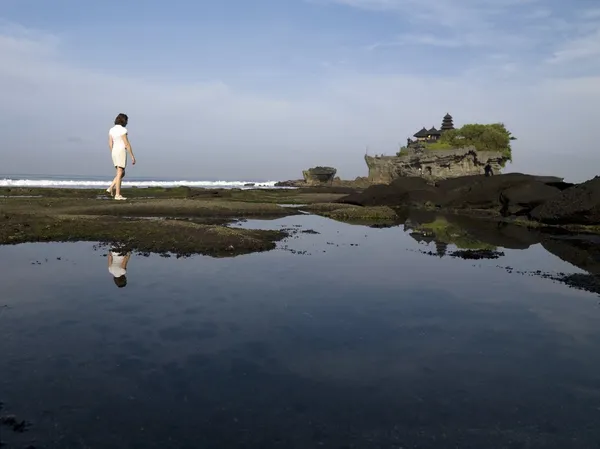 Tanah Lot Sea Temple, Bali, Indonesia. Woman Walking Along The Shore