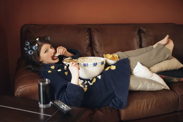 Girl on the couch eating popcorn