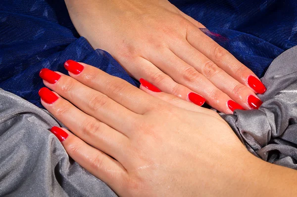 Beautiful female hands with red nail polish on the nails