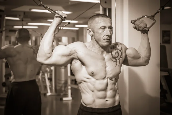 Man with a tattoo  exercising in gym