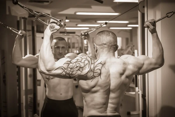 Man with a tattoo  exercising in gym