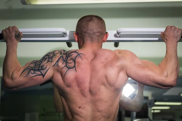 Man hanging from a pull up bar