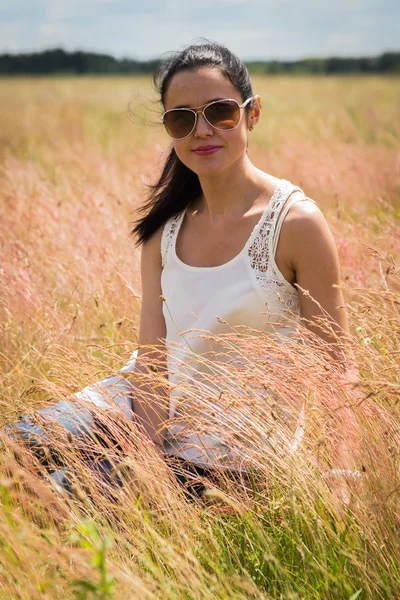 Girl in sunglasses in the field.