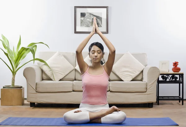 Woman meditating in a living room