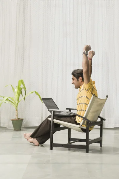 Man sitting in an armchair with a laptop