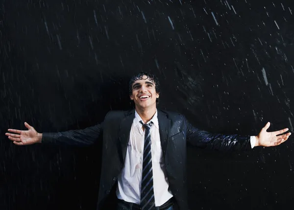 Happy businessman enjoying in the rain