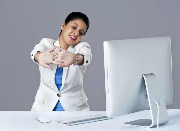 Businesswoman stretching in an office