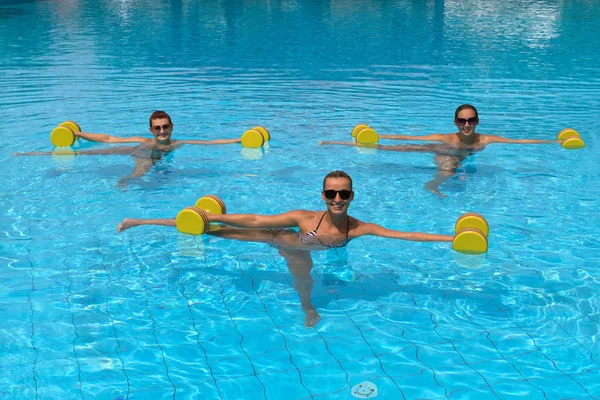 Happy active fitness people doing exercise with aqua dumbbell
