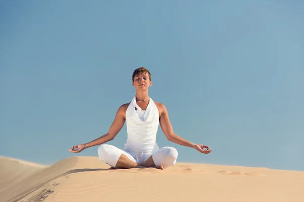 Yoga meditation on the beach, healthy female body in peace, woman sitting relaxed on sand over beautiful sea sunset, calm girl enjoying nature, active vacation lifestyle, zen spa, wellness concept