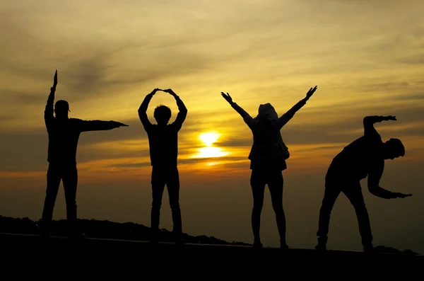 Love silhouette by four people on sunrise background