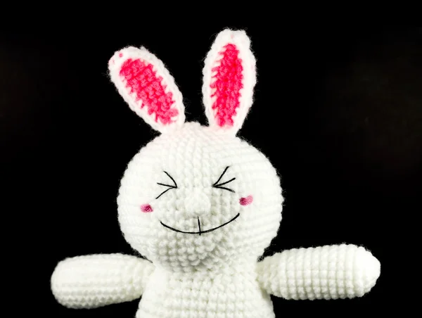 Closeup handmade crochet white rabbit doll on black background,f