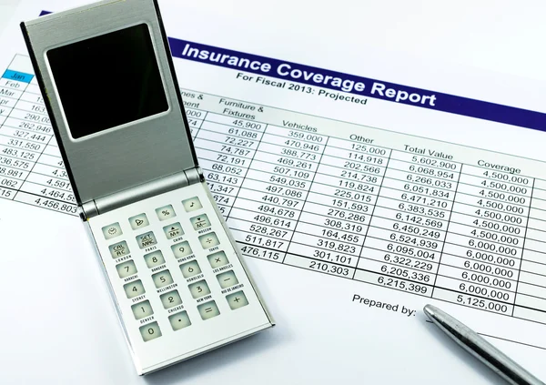 Insurance coverage report with calculator and pen for business