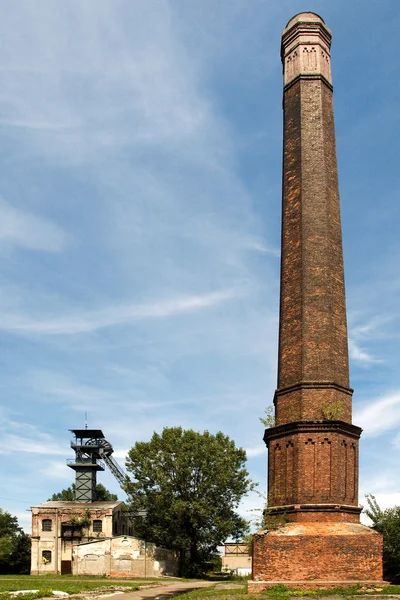 Old coal mine shaft with a mining tower in the foreground tall chimney.