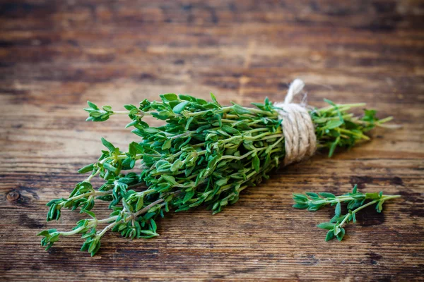 Bunch of fresh thyme on a wooden background